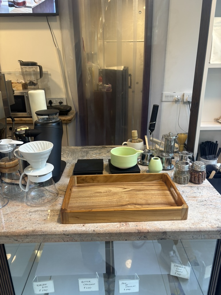 Alayna Cafe counter with a matcha bowl, whisk, pour-over setup, and coffee equipment